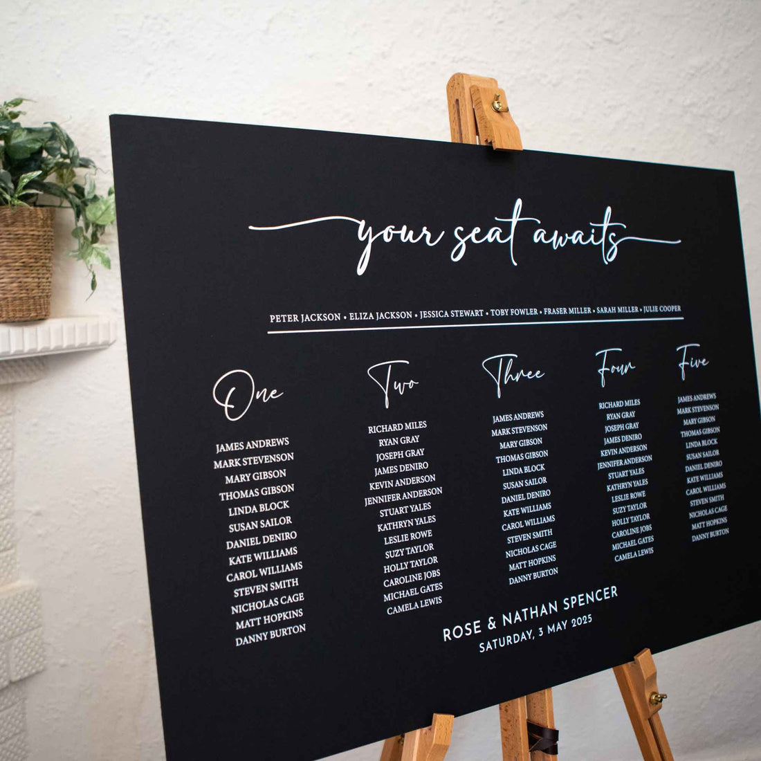 Personalised wedding seating chart in black foam board says your seat awaits