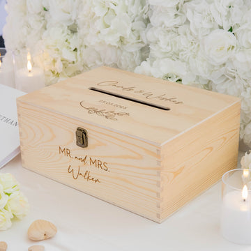 Wooden card box with engraved text against a floral background