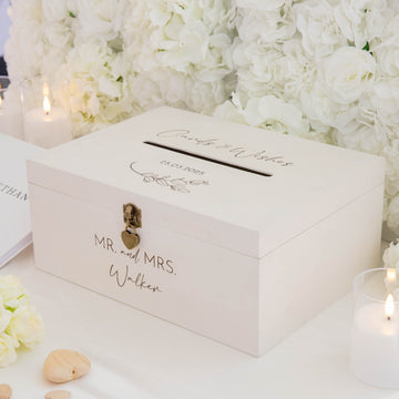 White wedding card box with 'Mr. and Mrs. Walker' engraving, surrounded by white flowers and candles.